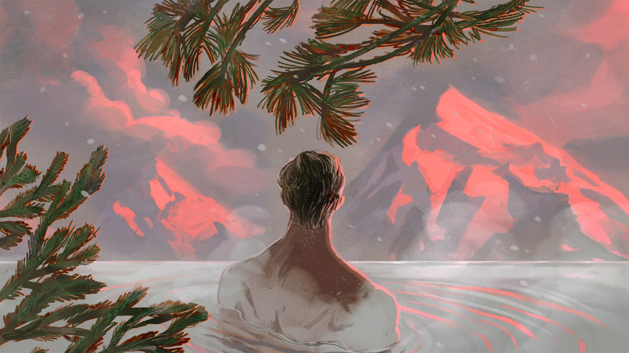 A man soaking in a hot spring with mountain views