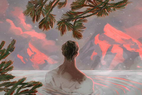 A man soaking in a hot spring with mountain views