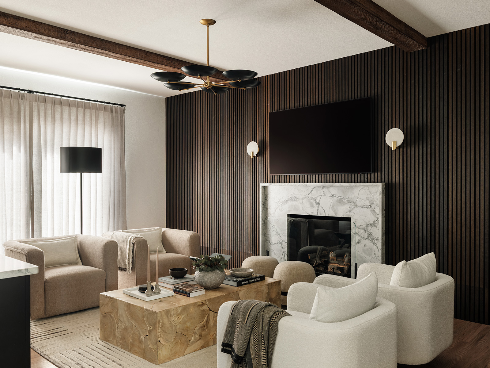 Lounge with cream colored seating and a wood-slat fireplace