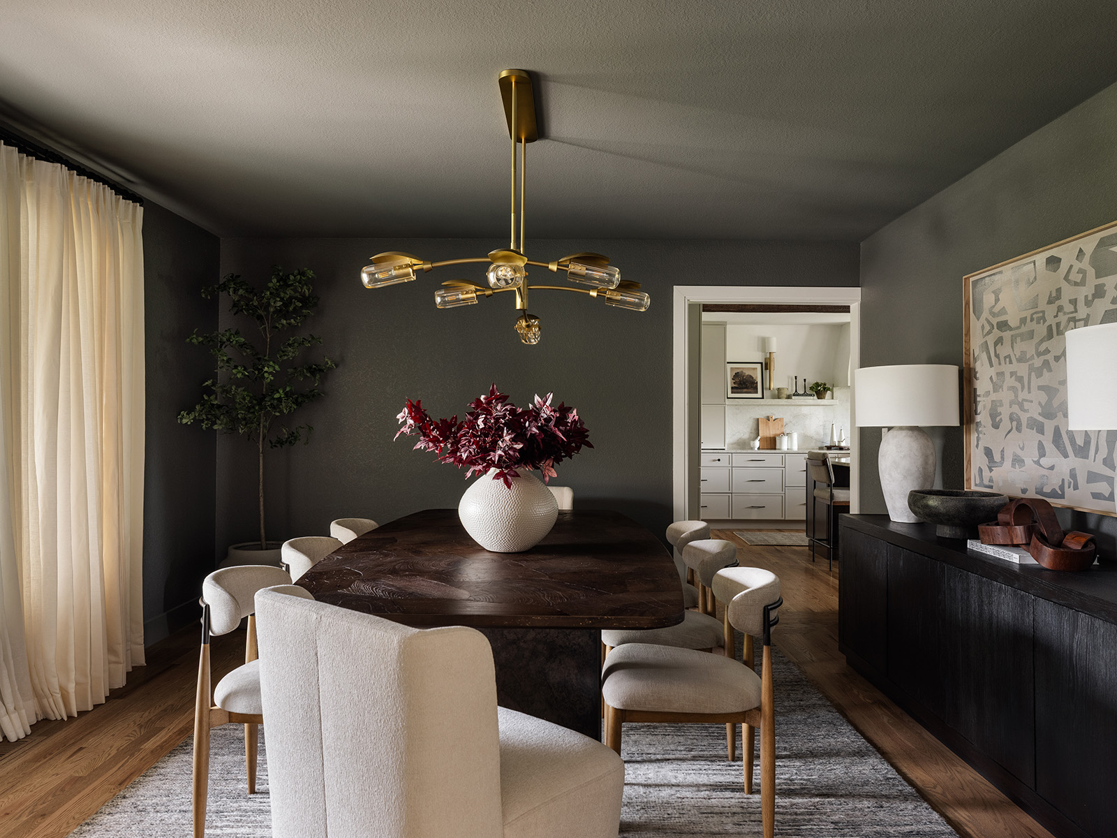 Dark gray dining room with dark wood dining room table and white chairs