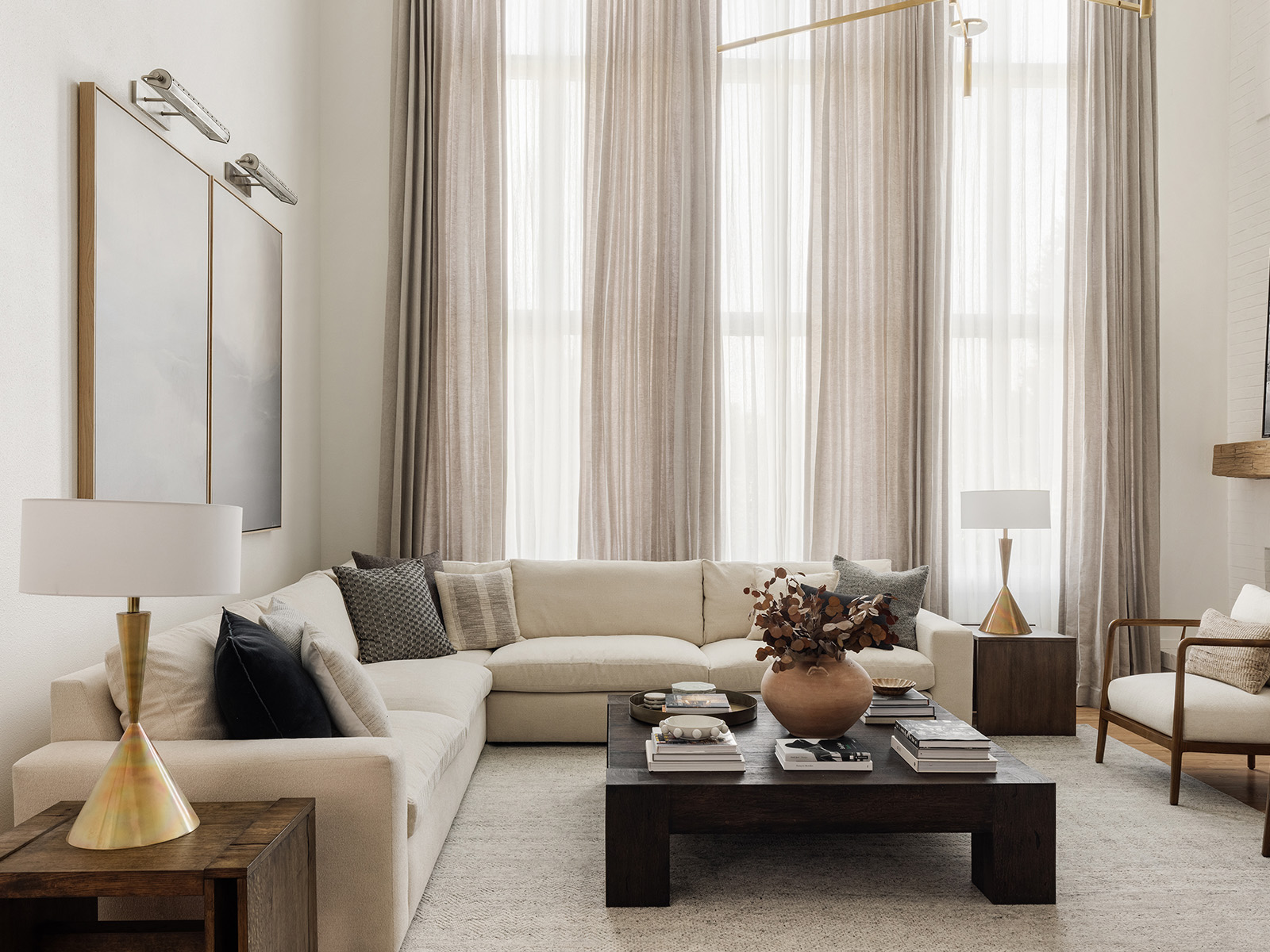 White living room with a white sofa and floor-to-ceiling windows with sheer drapes