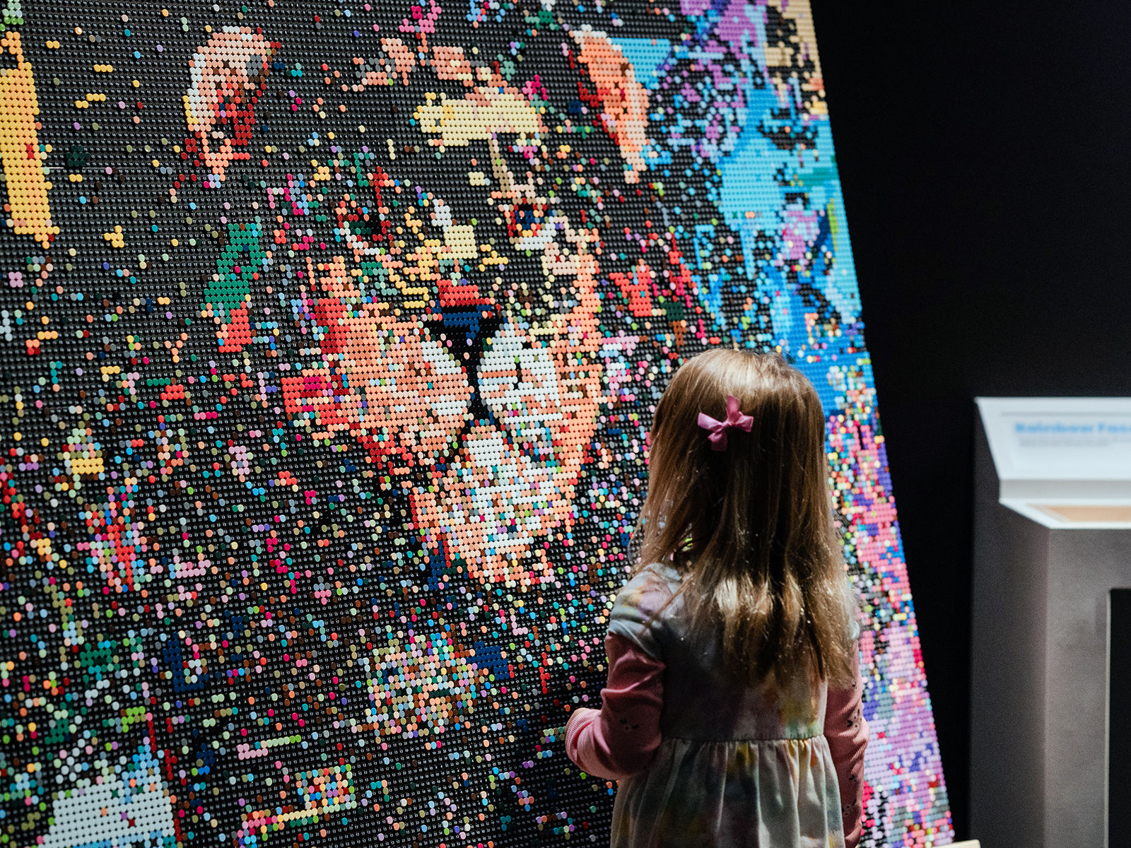 A little girl checks out a Lego display of a lion at Brick Planet in Denver