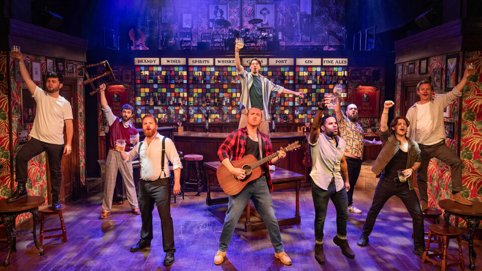 Troupe of men sing in a bar