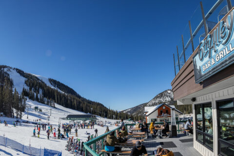 People hanging on the deck of 6th Alley Bar & Grill at Arapahoe Basin
