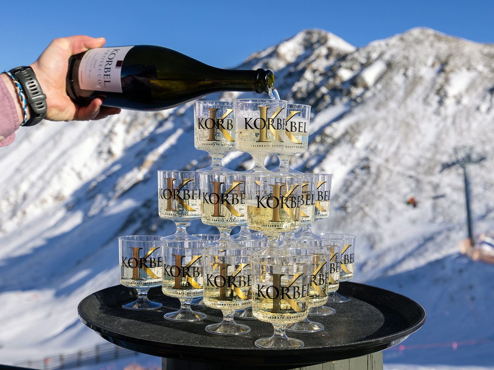 Pouring a bottle of champagne over a castle of flutes at A-Basin