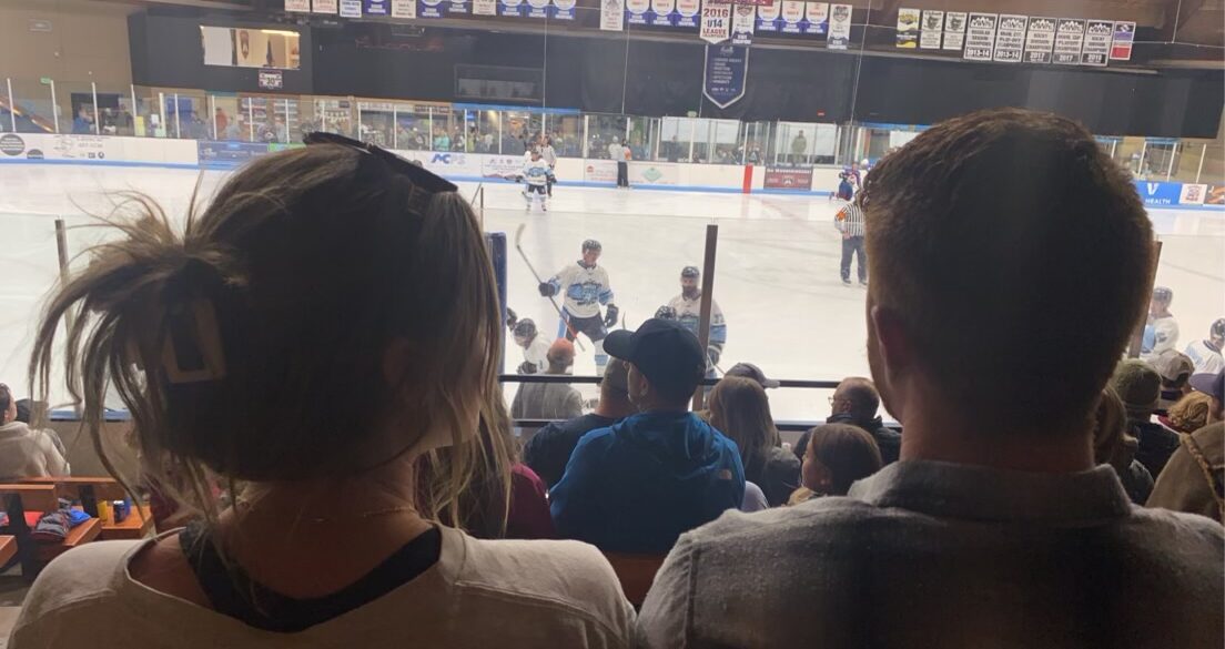 Valerie Turgeon and Garrett Klee sit next to each other at the Avalanche reunion charity game