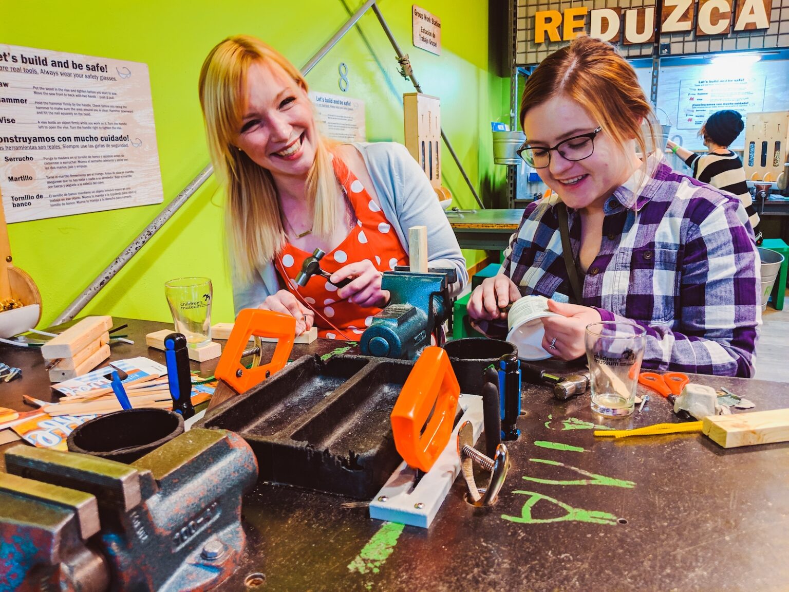 Two women with pint glasses making crafts
