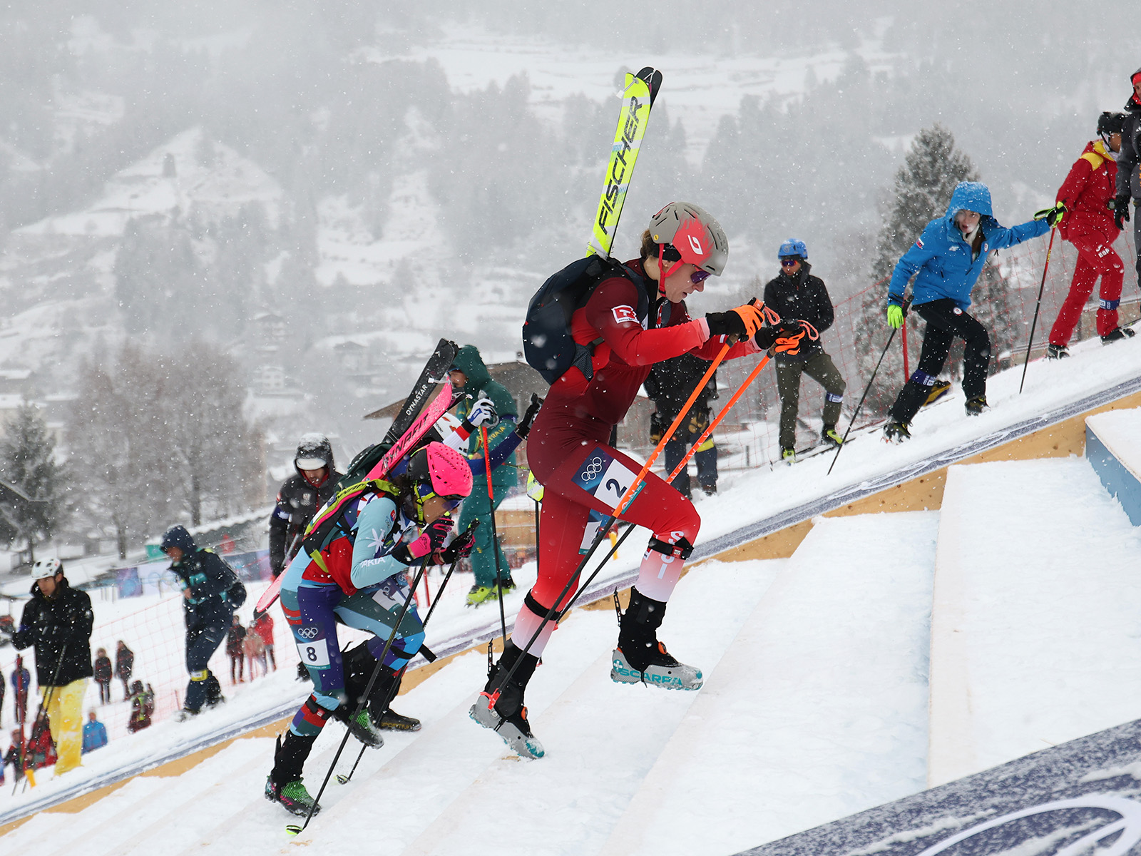 Women bootpacking during the Olympic ski mountaineering women's sprint event