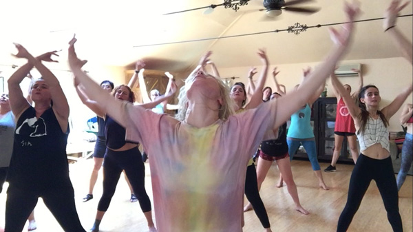 A group of people moving in a dance class.