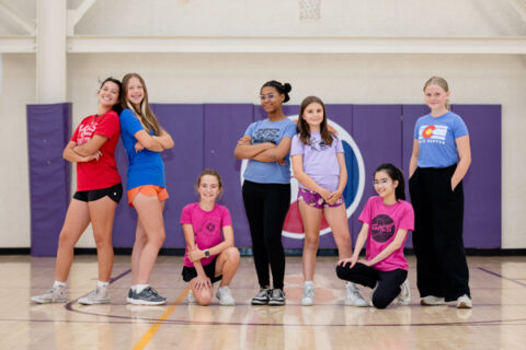A group of girls posed together on a basketball court.