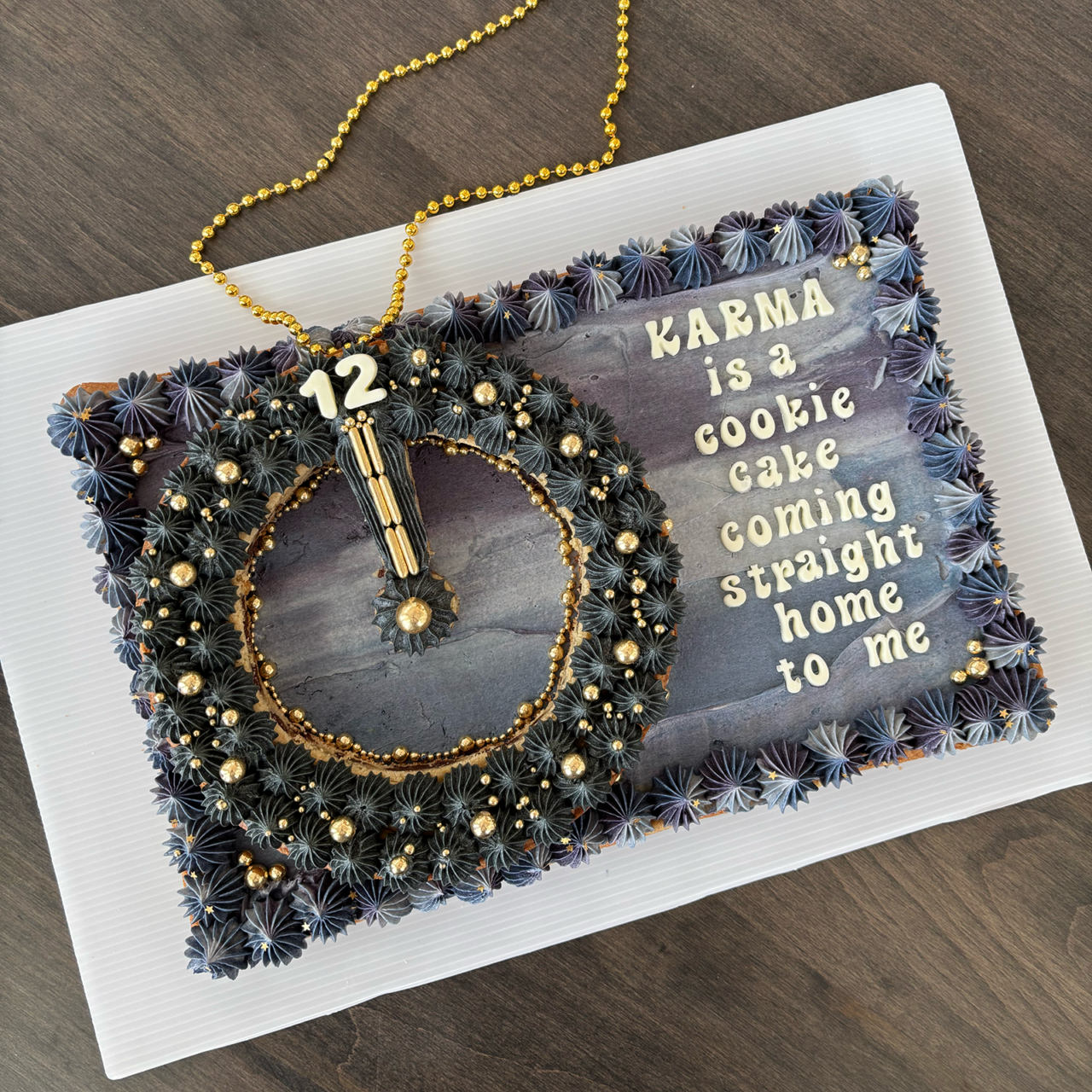 Cake with a clock stopped at midnight and lyrics from Taylor Swift's "Karma"