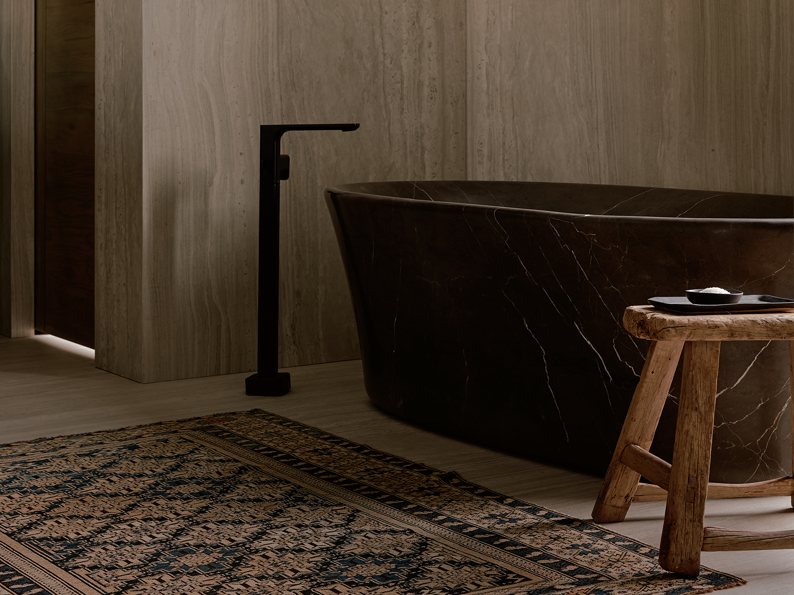 Black marble bathtub with a patterned rug