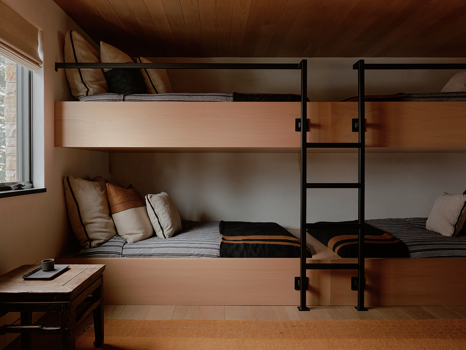 Bunk beds connected by a black metal ladder