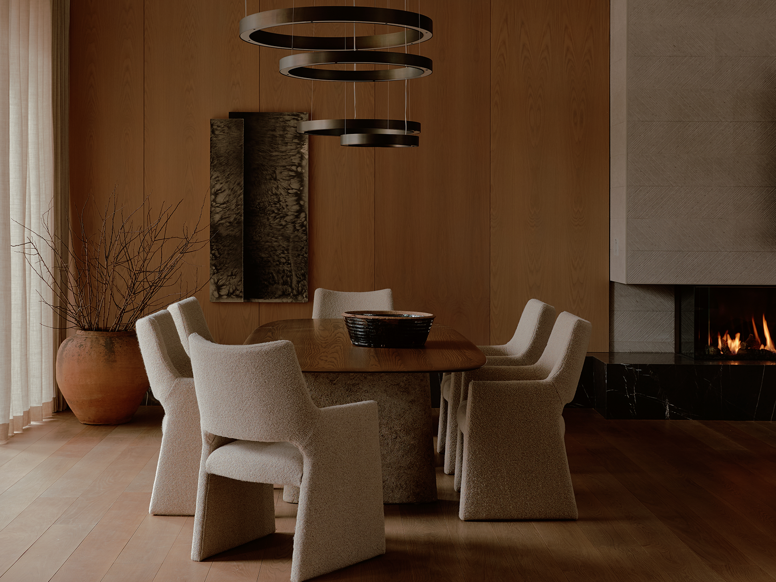 Dining room with large white chairs and a black circular chandelier