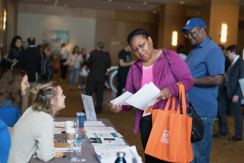 A woman looking a flyer at a diabetes event.