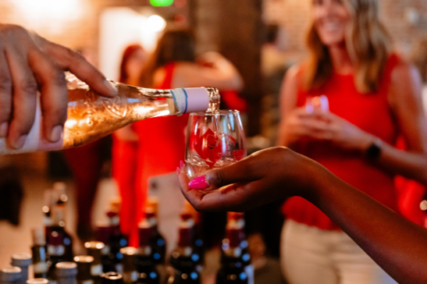 Someone pouring a glass a wine at an event.