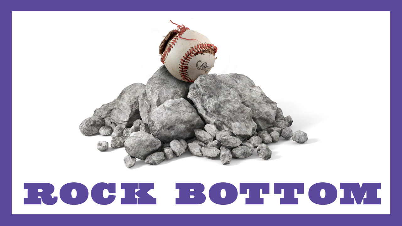 A Colorado Rockies baseball on a pile of rocks