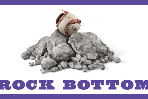 A Colorado Rockies baseball on a pile of rocks