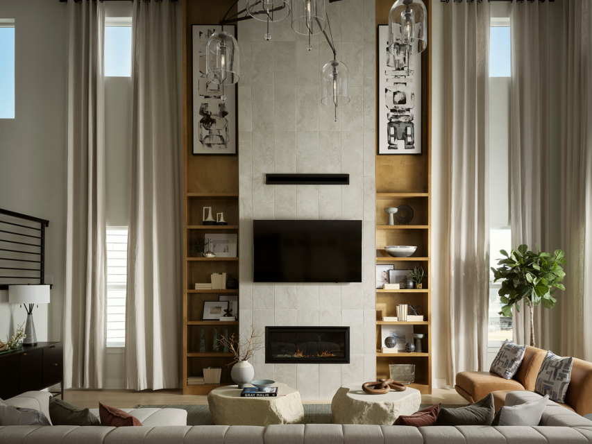 A living with room with high ceiling, a glass light fixture and wooden insert shelves