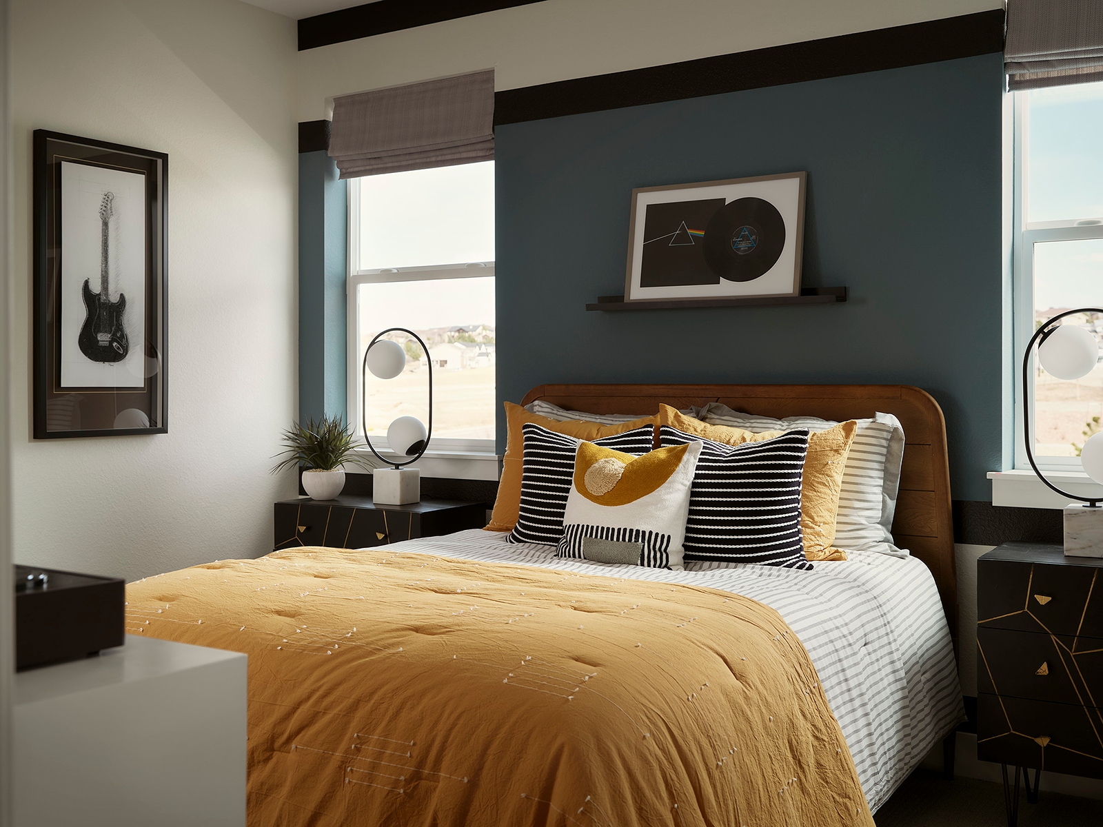 Bedroom with two unusual lamps and yellow bedding