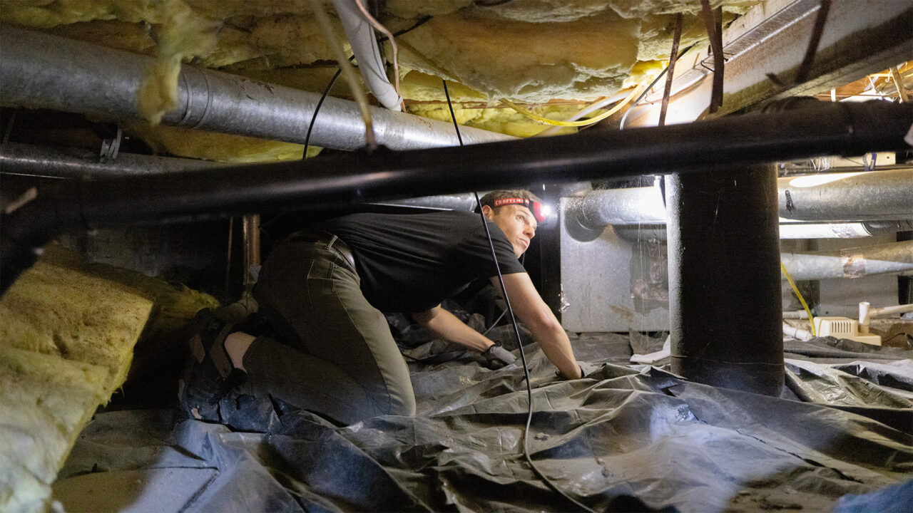 A man inspecting a home’s insulation
