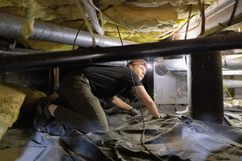 A man inspecting a home’s insulation