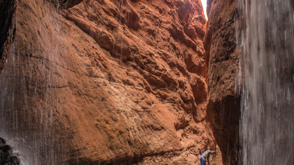 A hiker and his dog in Mary Jane Canyon in Moab, Utah