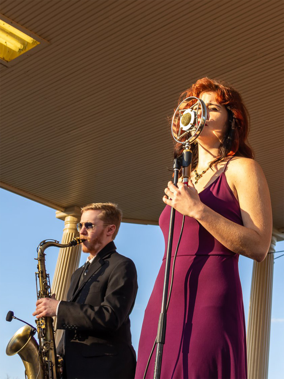 A woman singing and a man playing the saxophone at City Park Jazz in Denver