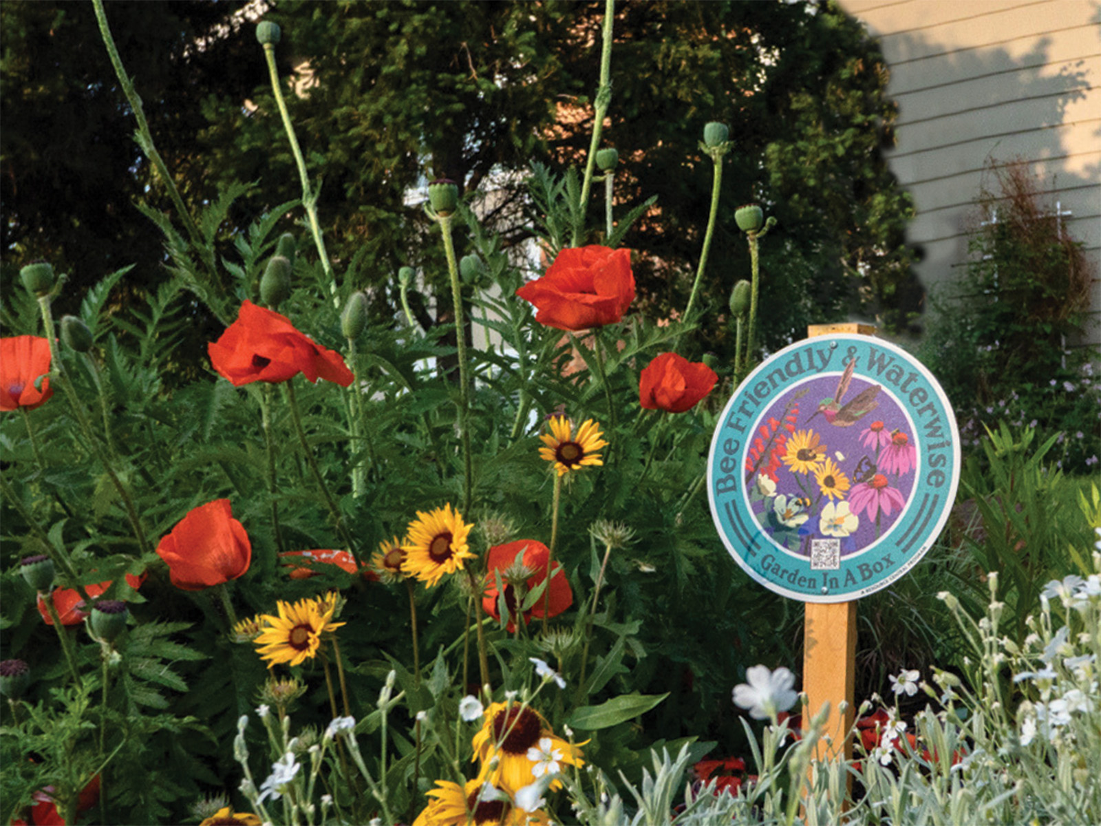 A sign in a flowerbed 
