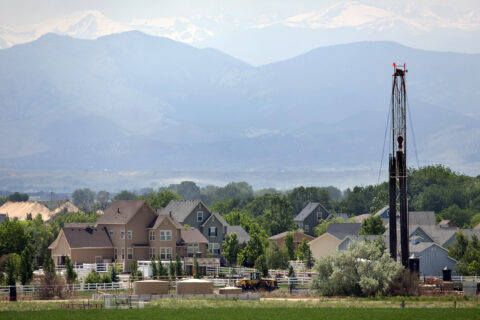 A drilling rig in front of homes in Weld County