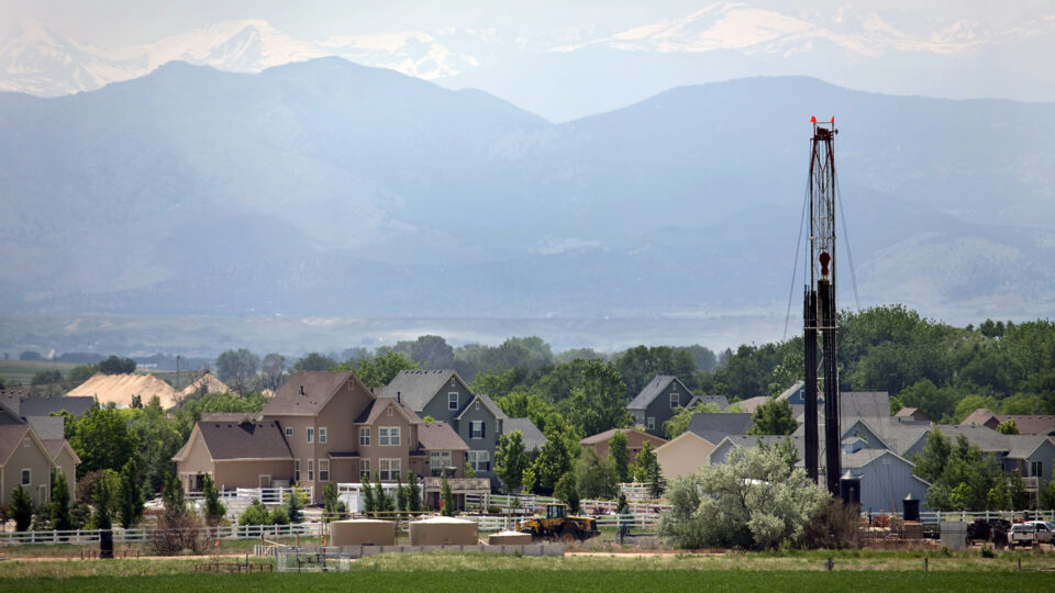 A drilling rig in front of homes in Weld County
