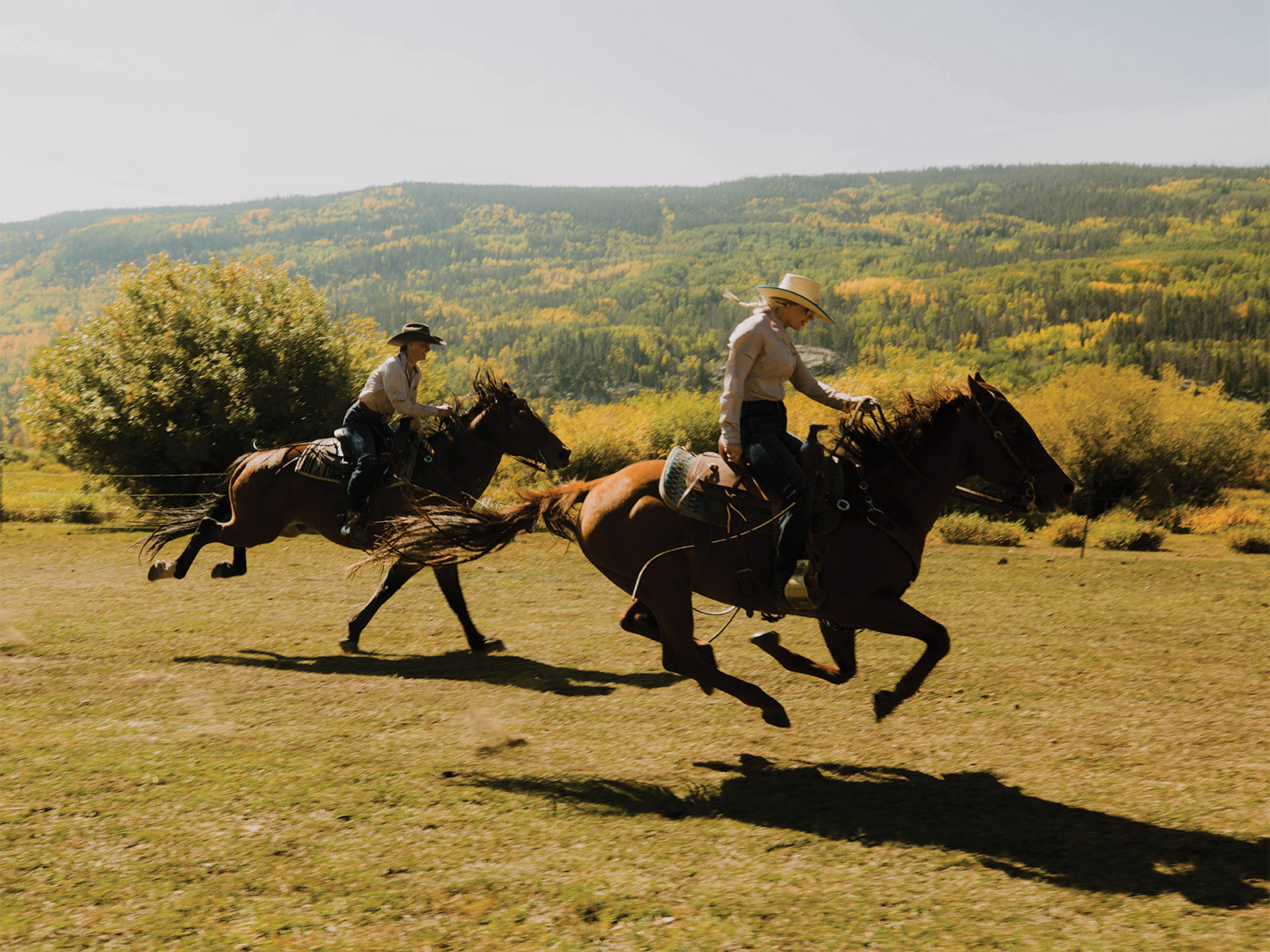 Two people riding horses at Rawah Ranch