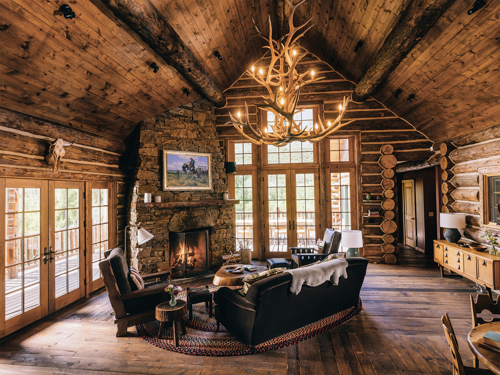 A lounge area with an antler chandelier at Smith Fork Ranch