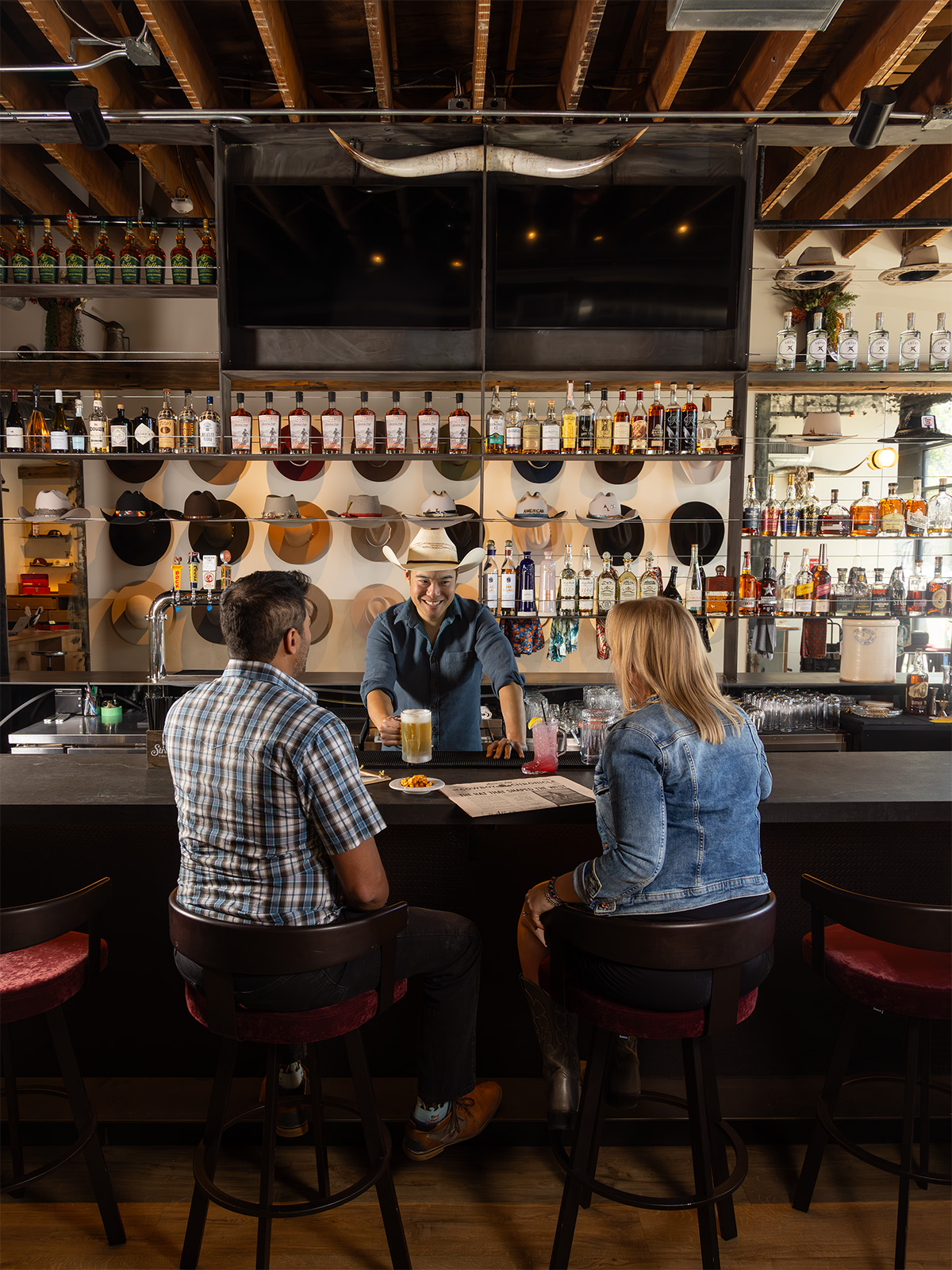 Two people sitting on the barstools at American Lore