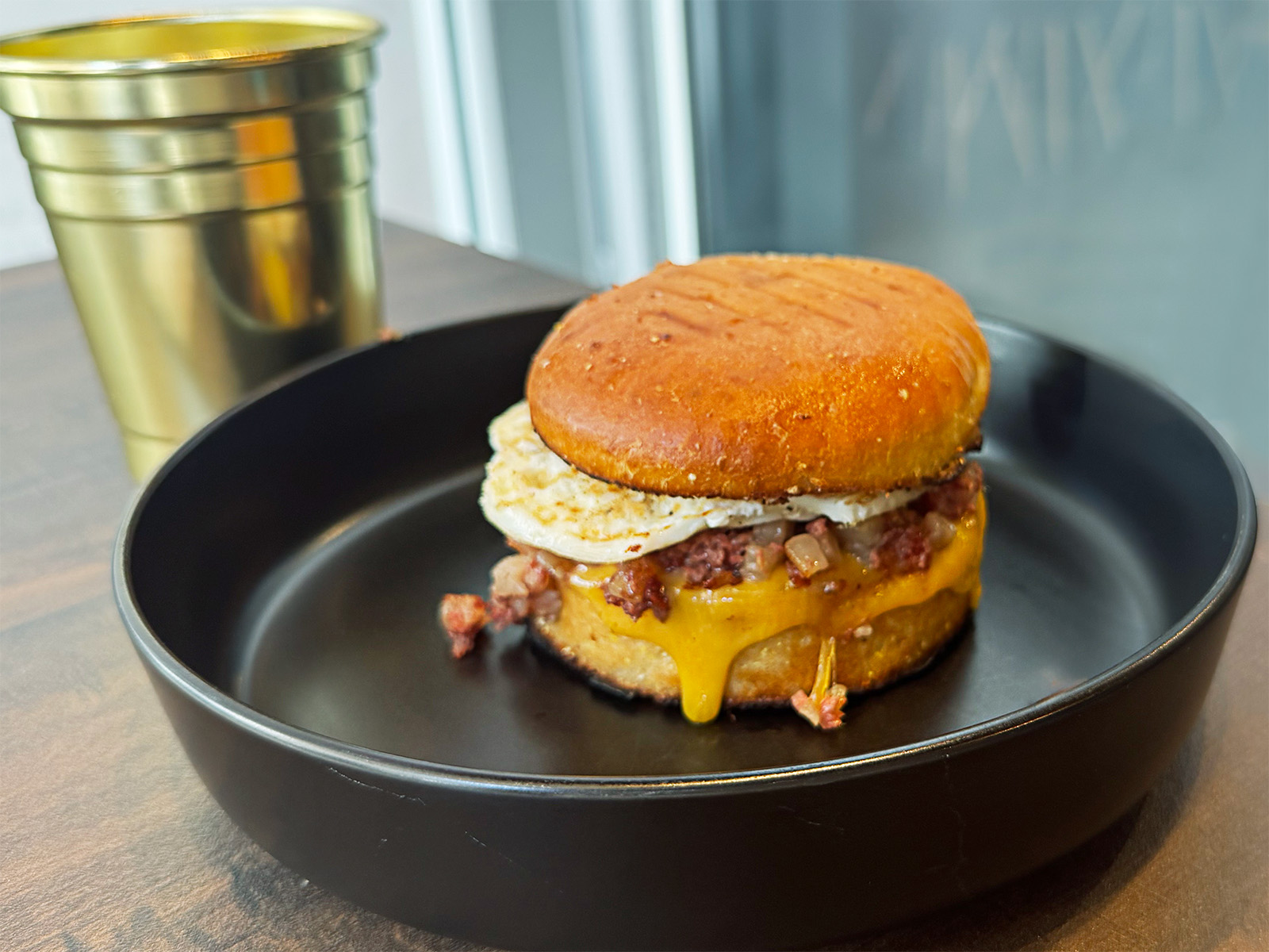 A breakfast sandwich on an English muffin with drippy cheese from Bakewell