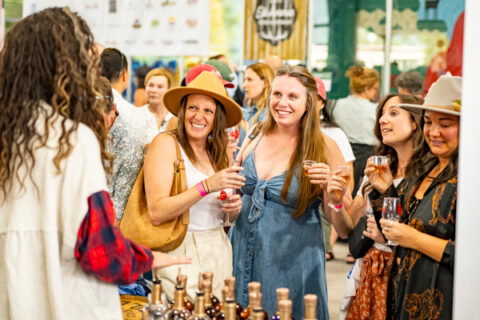 A group of women sampling different wines at a wine and food festival.