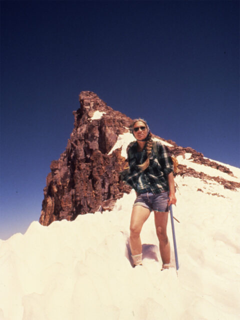 Dolores LaChapelle in shorts on a snowy mountain