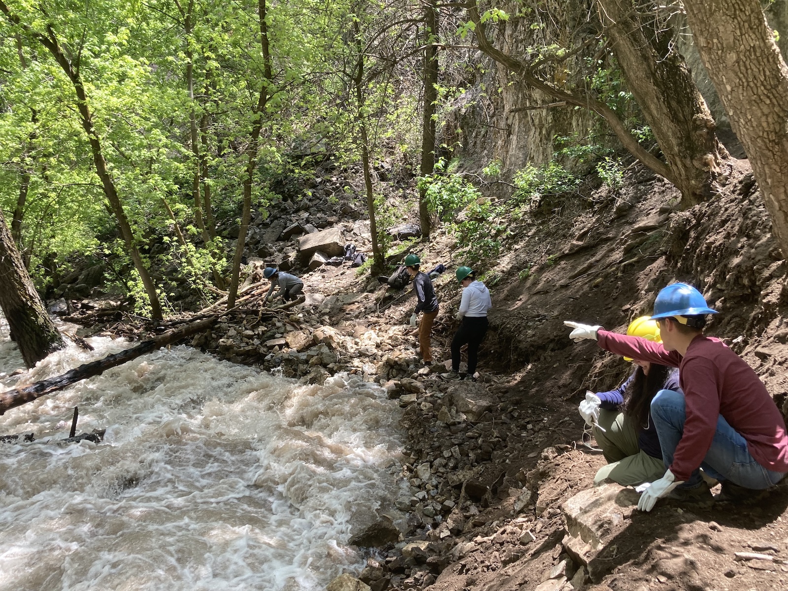 Workers in hard hats along Hanging Lake trail's creek 