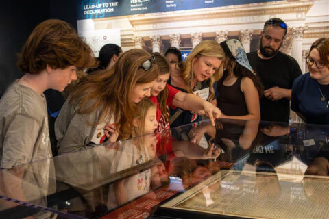 A group of people looking at artifacts in a museum.