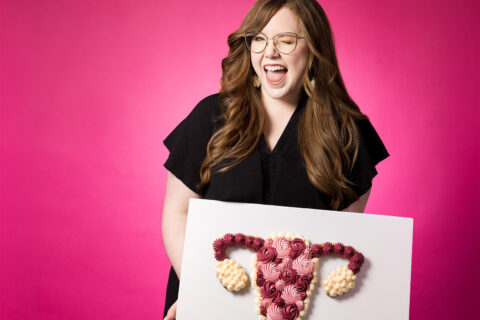 Woman holds a cookie cake of a uterus