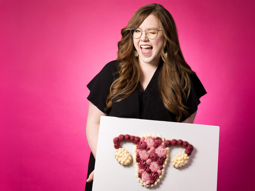 Woman holds a cookie cake of a uterus