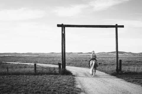 Binion Cervi riding a horse on a ranch