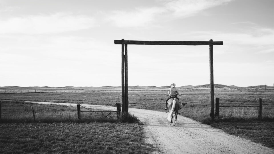 Binion Cervi riding a horse on a ranch