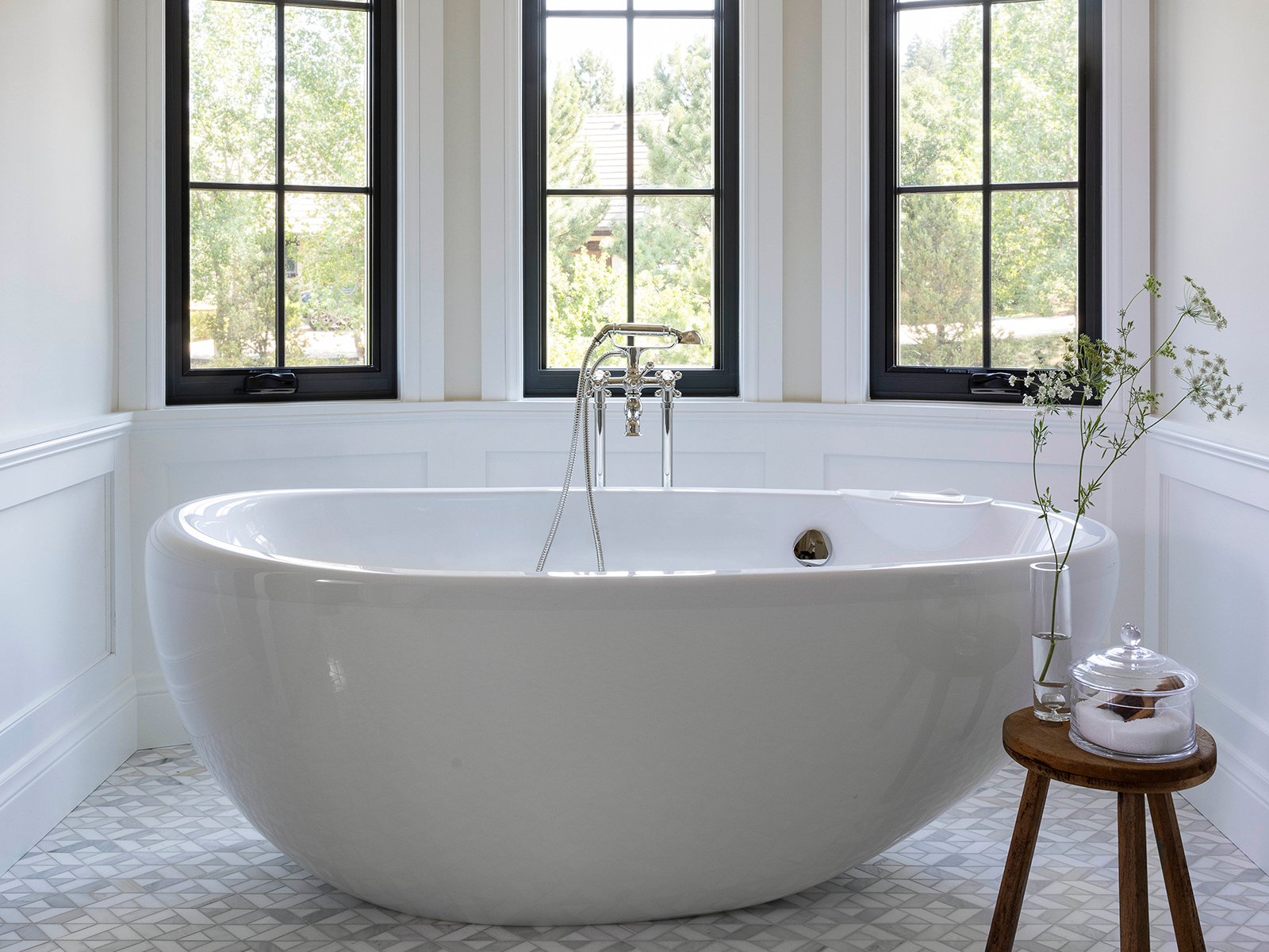 Large windows behind a freestanding white tub