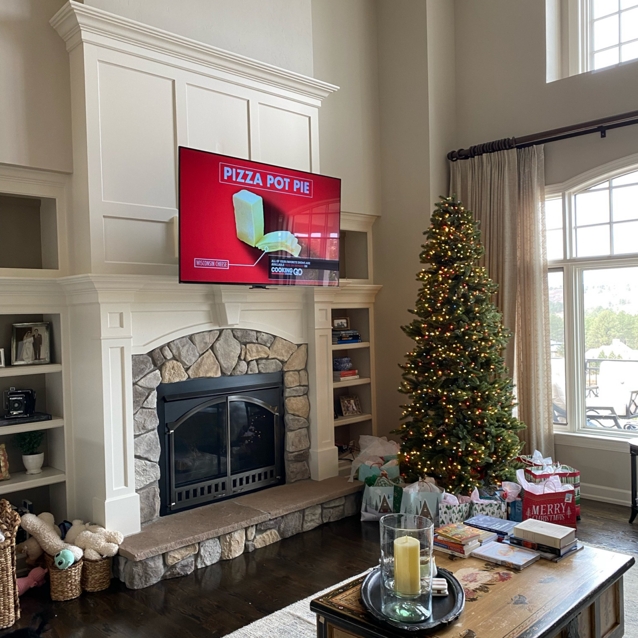 Living room with a stone fireplace and large TV