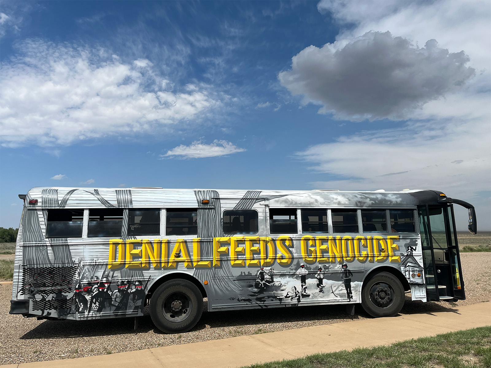 A museum exhibit in a school bus that says DENIAL FEEDS GENOCIDE