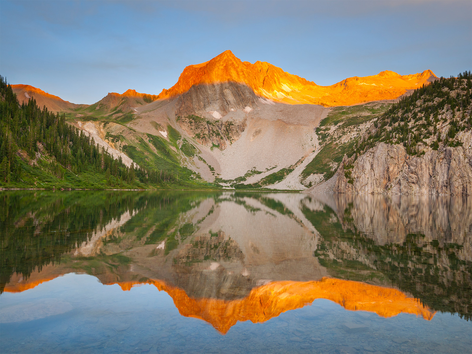 Snowmass Mountain reflects into Snowmass Lake in Colorado, along the Three Pass Loop