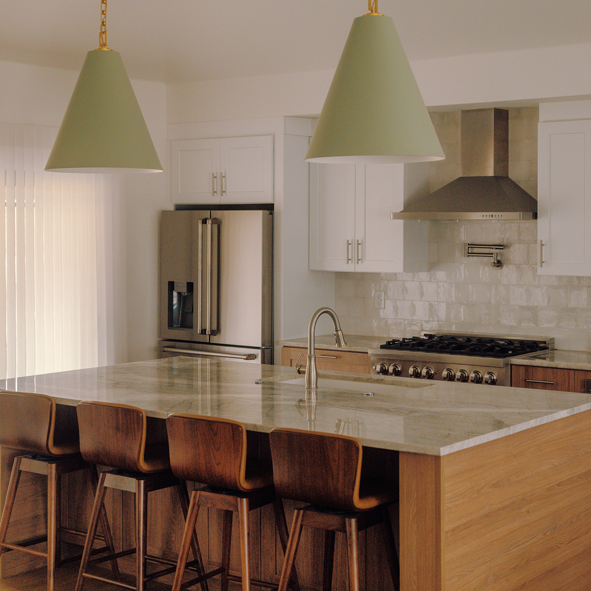 White kitchen with sage-green pendant lights over an island