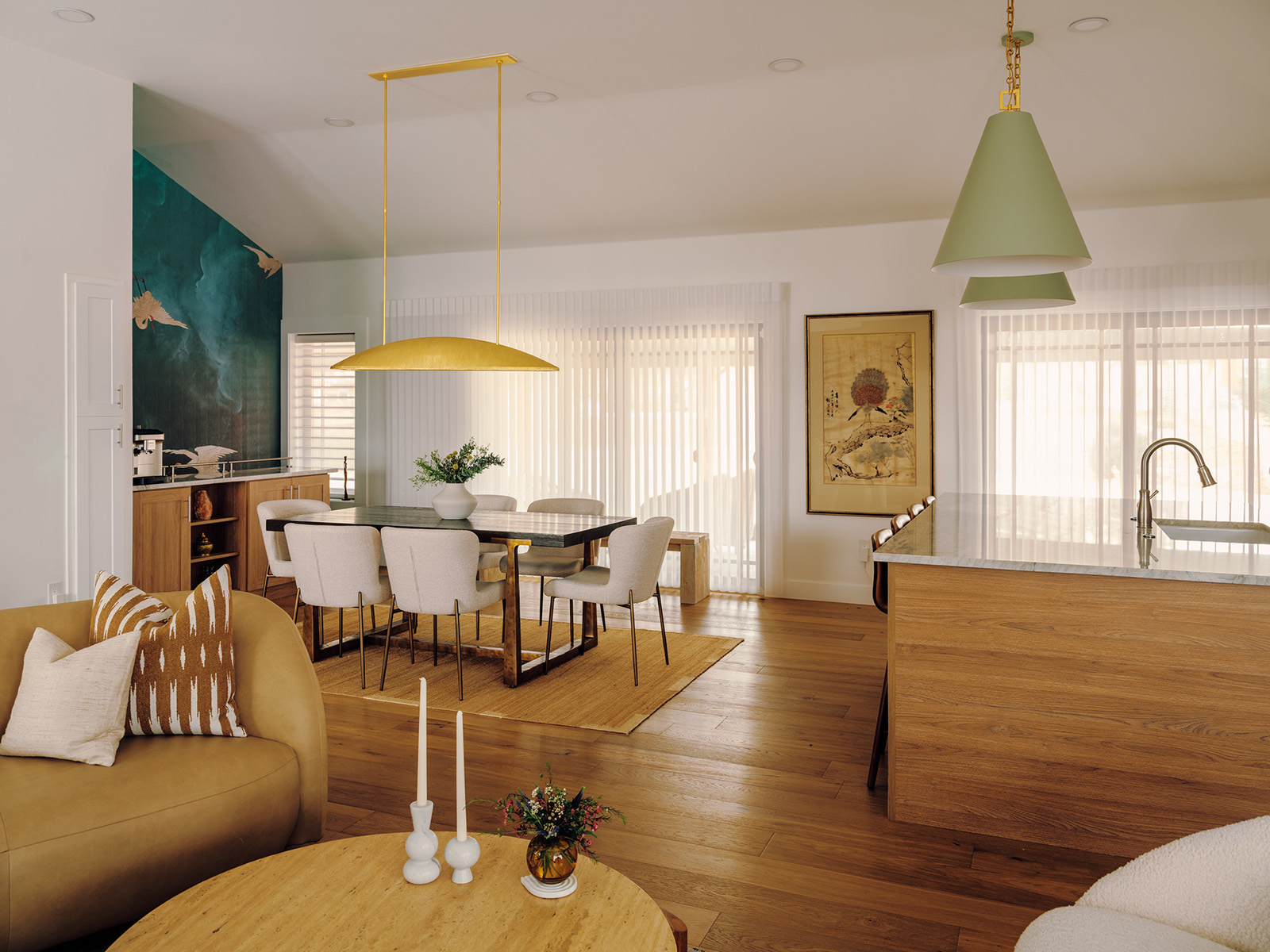 Open-concept kitchen and dining room with a gold light fixture over the table