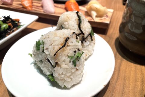 Two onigiri rice balls on a white plate at a Japanese restaurant